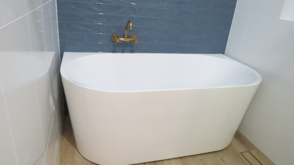 White back to wall freestanding bath against the blue tile backdrop makes stunning look - Kangaroo Point QLD