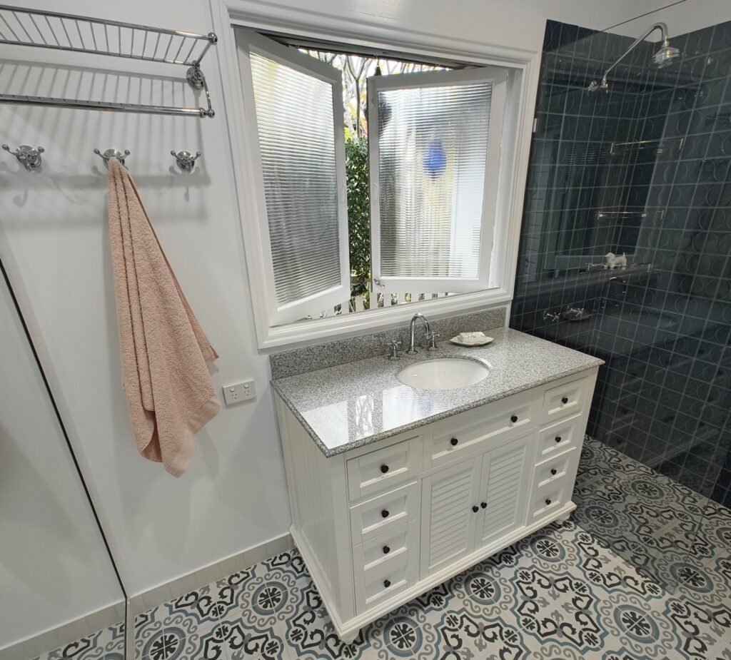 Graceville bathroom renovation with antique-style Early Settler vanity under the window and chrome tapware