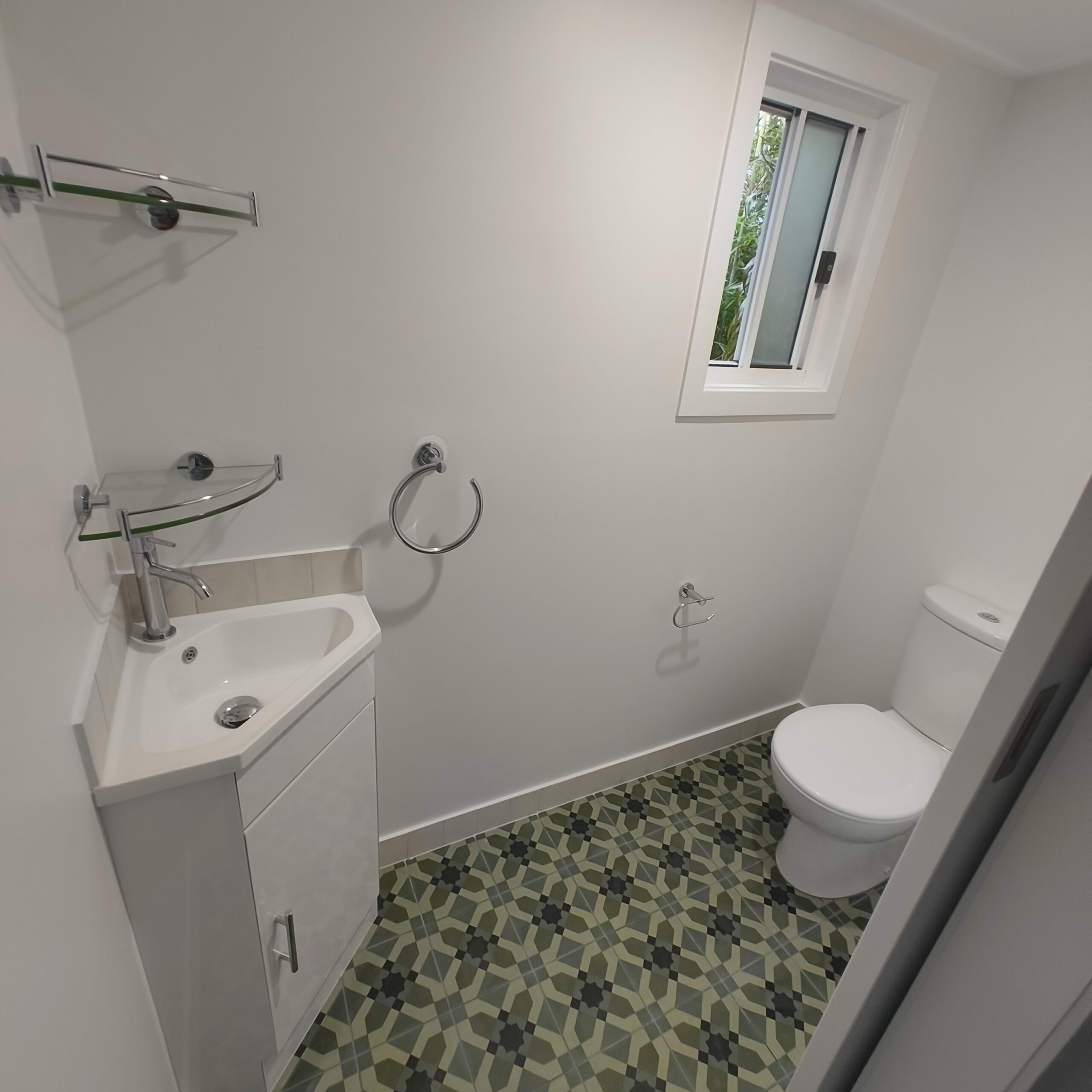 Renovated separate toilet in a Graceville Queenslander with new window framing and mosaic floor tiles