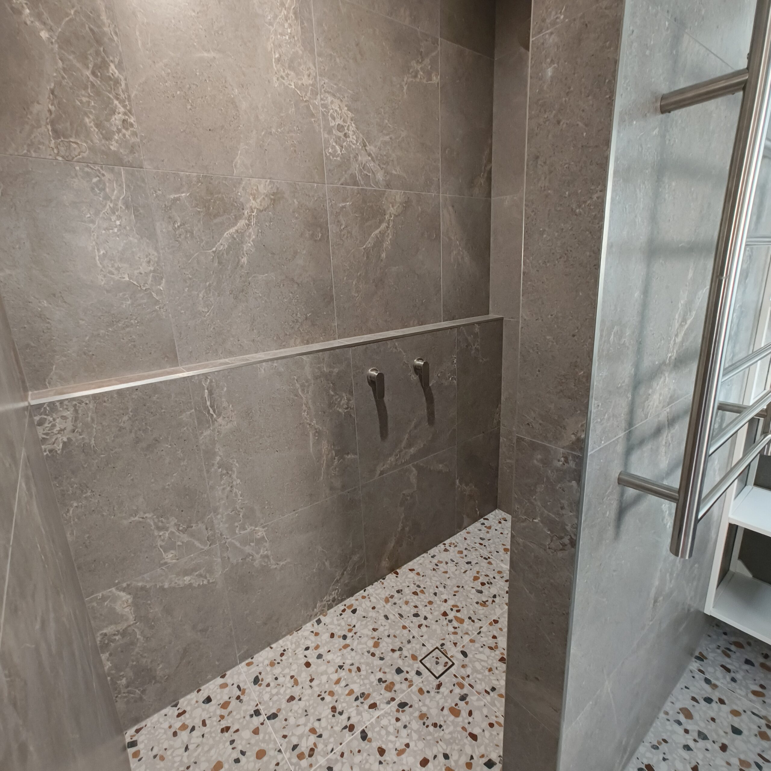 Ardesia Ash Brown honed wall tiles and Agglo Murano terrazzo-look floor tiles in the renovated East Brisbane shower