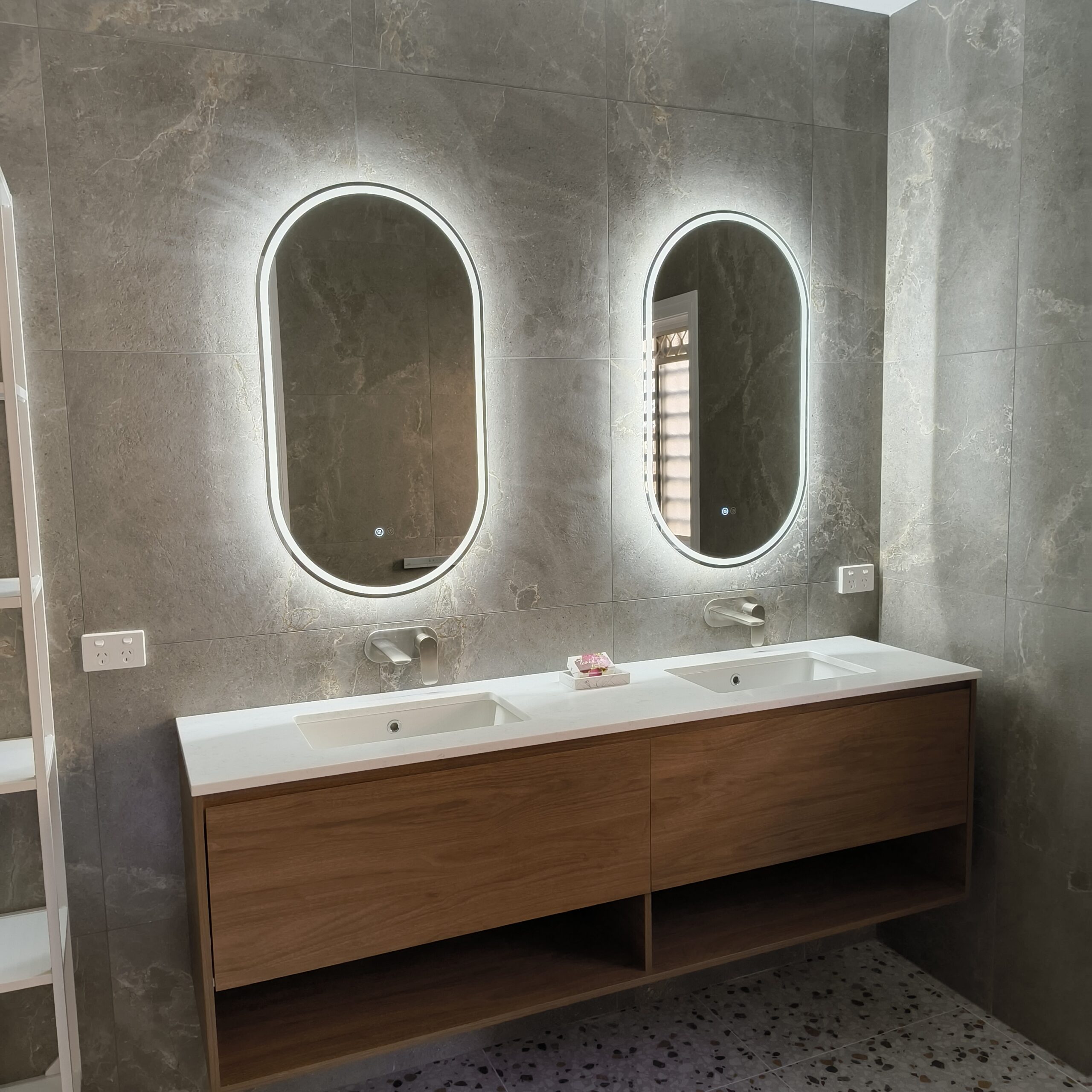 Twin Ilume pill LED demister mirrors above the walnut double vanity in the East Brisbane ensuite