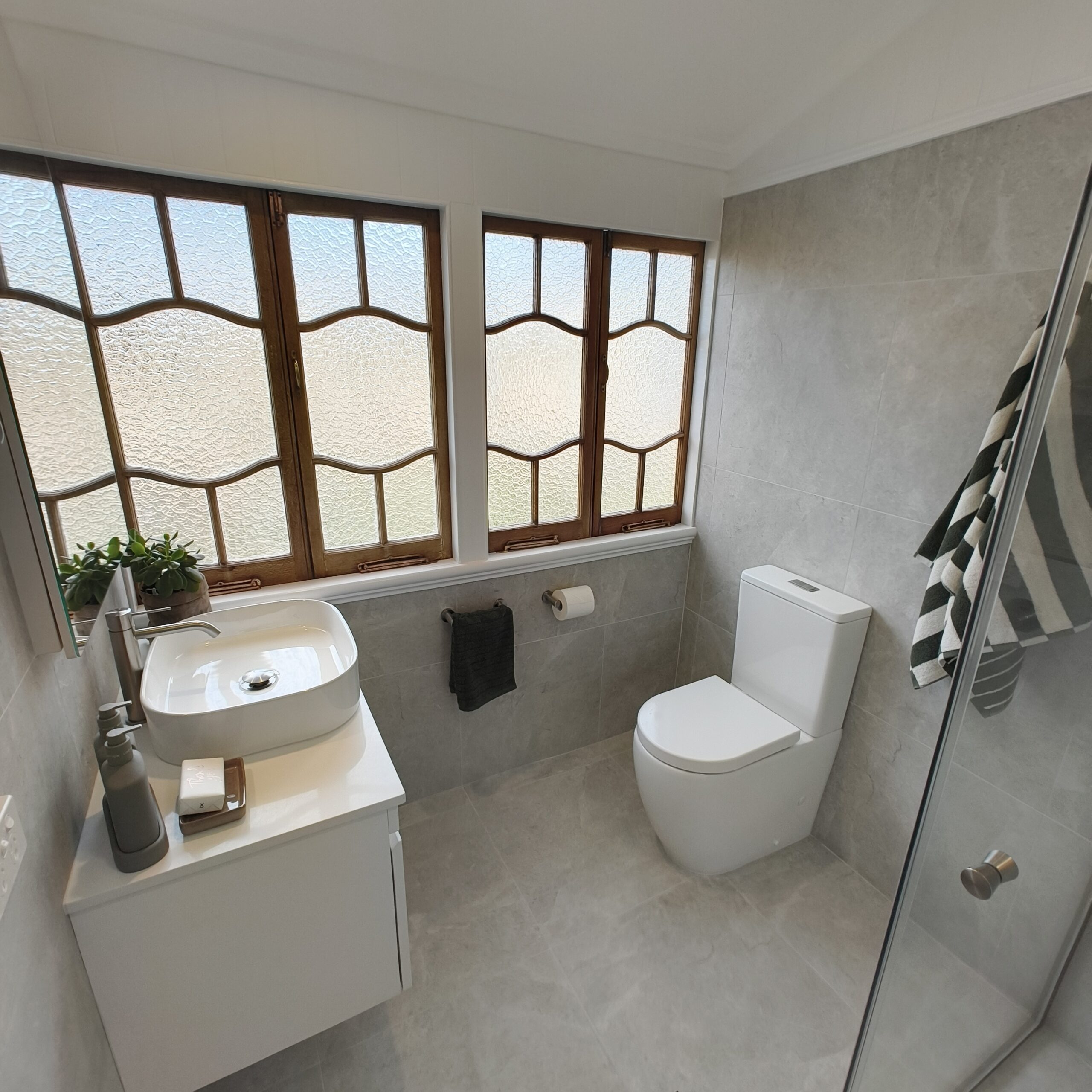 Woolloongabba main bathroom renovation with retained leadlight casement windows, wall-hung vanity and vessel basin