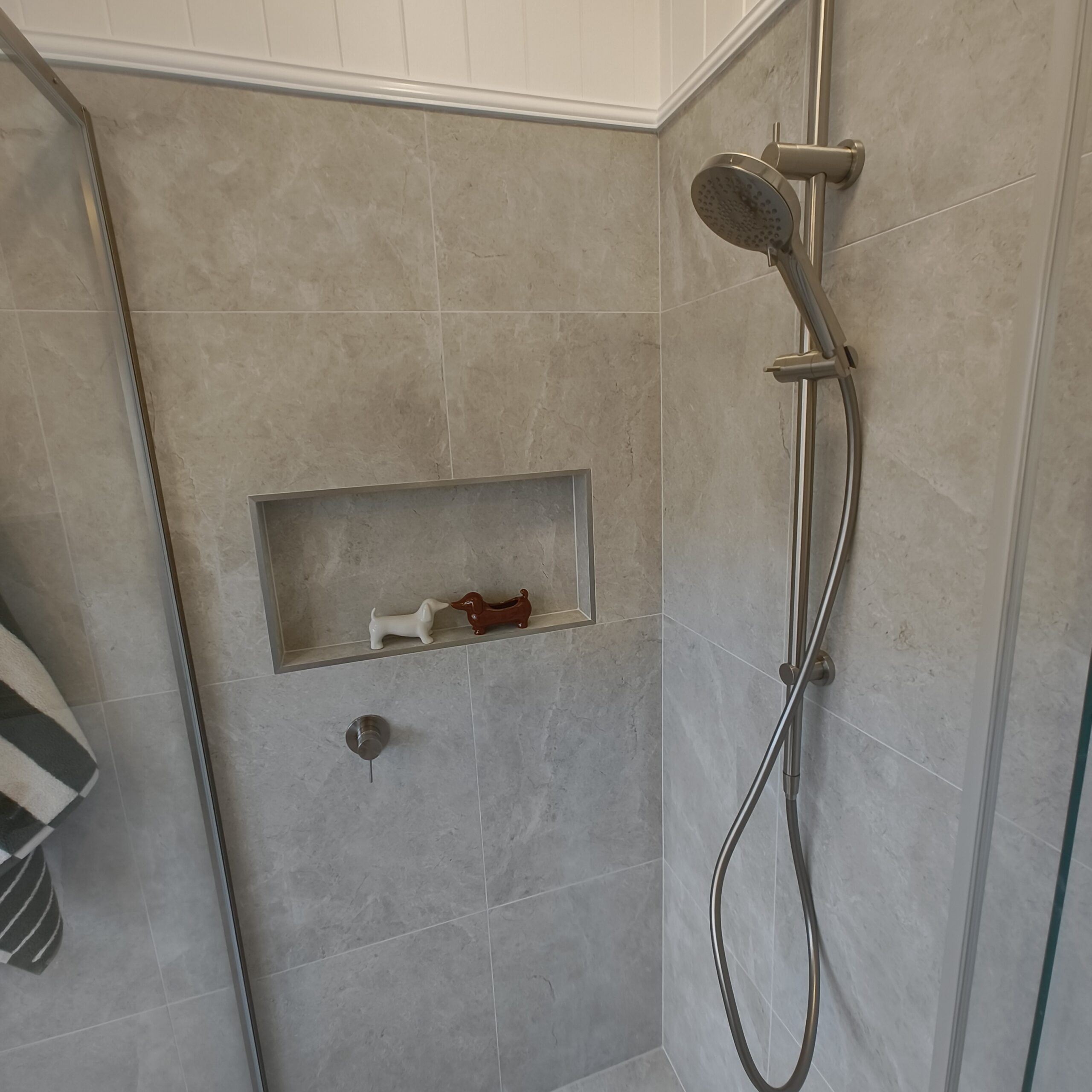 Renovated Woolloongabba main bathroom shower with stone-look tiles, niche and brushed nickel rail shower