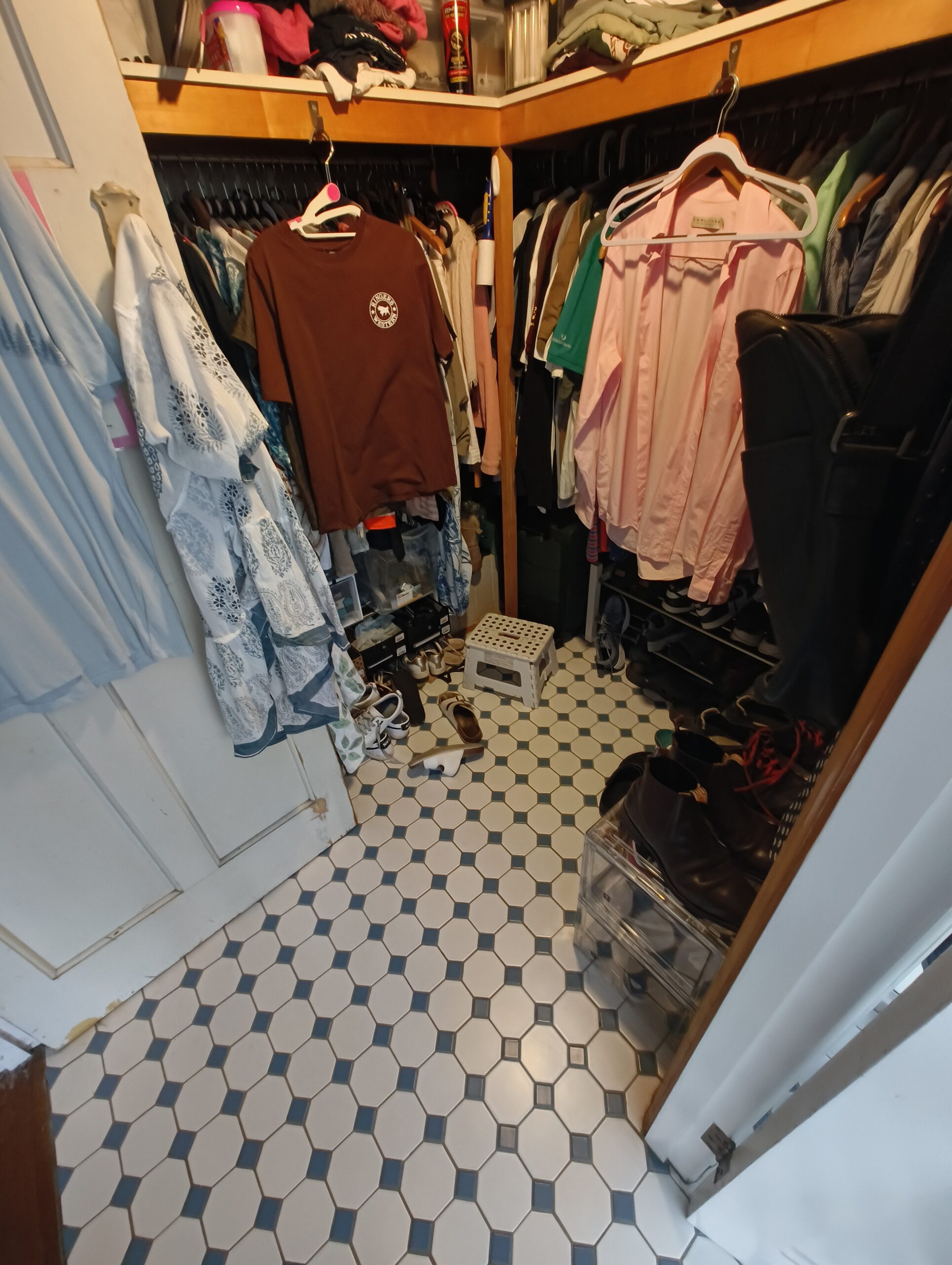 Woolloongabba walk-in robe before renovation with dated timber shelving