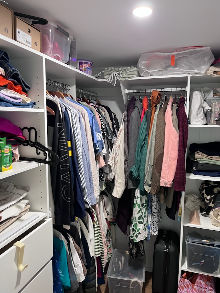 Open walk-in robe after renovation with white shelving, drawers and double hanging space