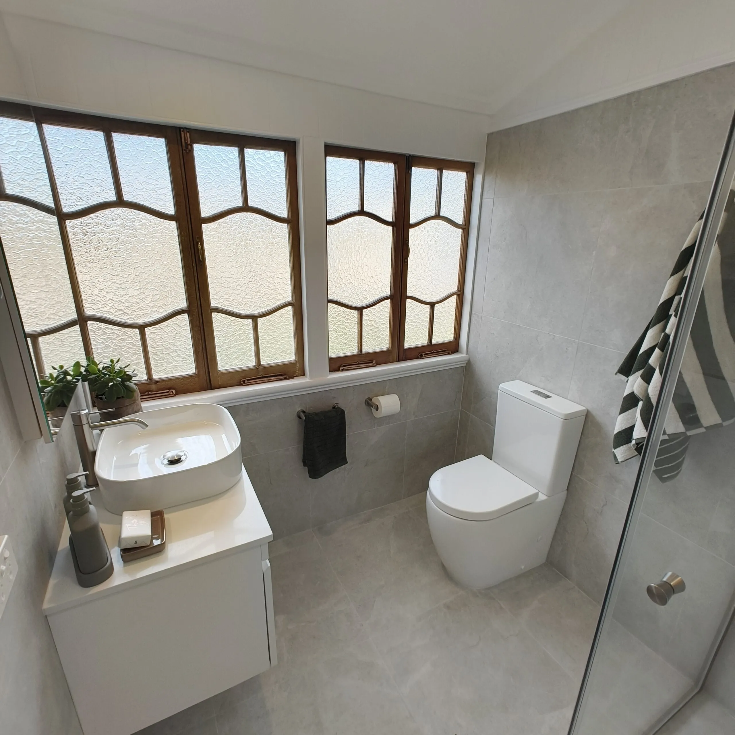 Woolloongabba main bathroom renovation with retained leadlight casement windows, wall-hung vanity and vessel basin