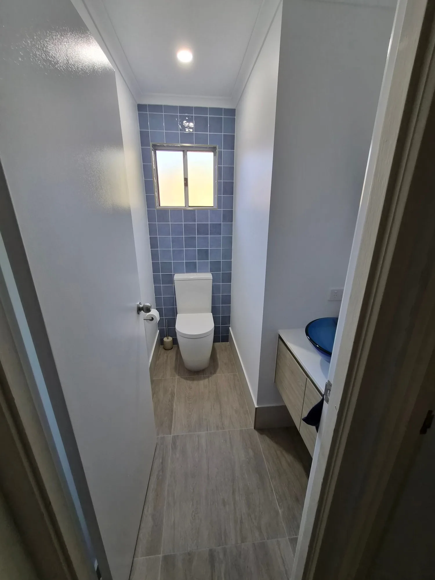 Red Hill powder room after renovation with blue feature wall, new window and timber-look vanity