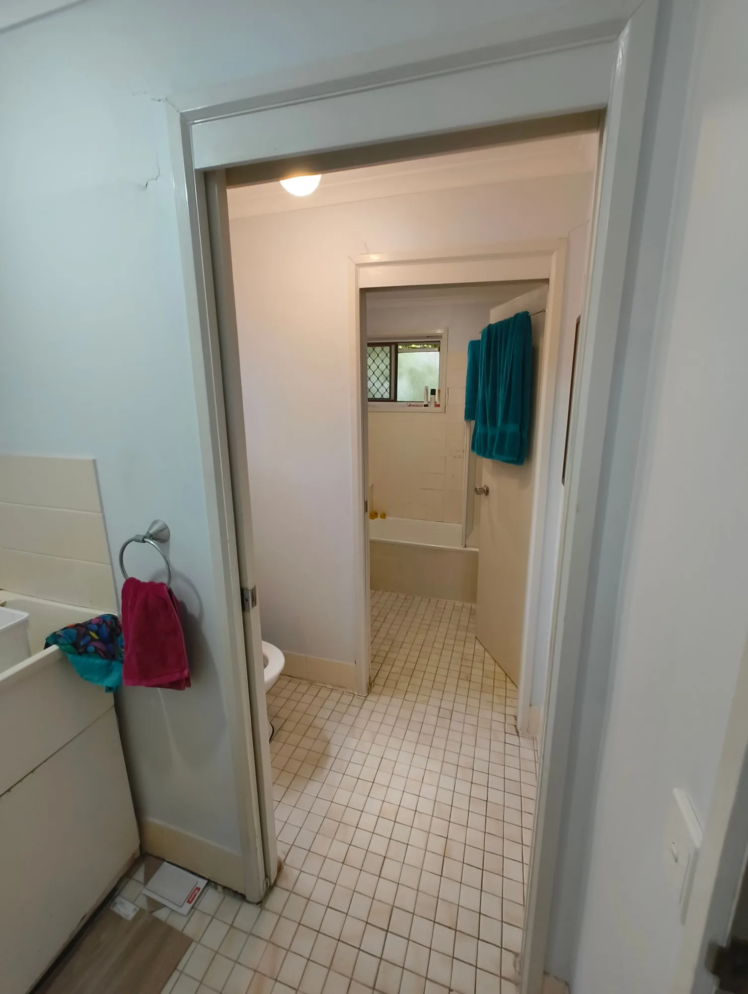 Looking through the old toilet to the bathroom in the Red Hill townhouse before renovation